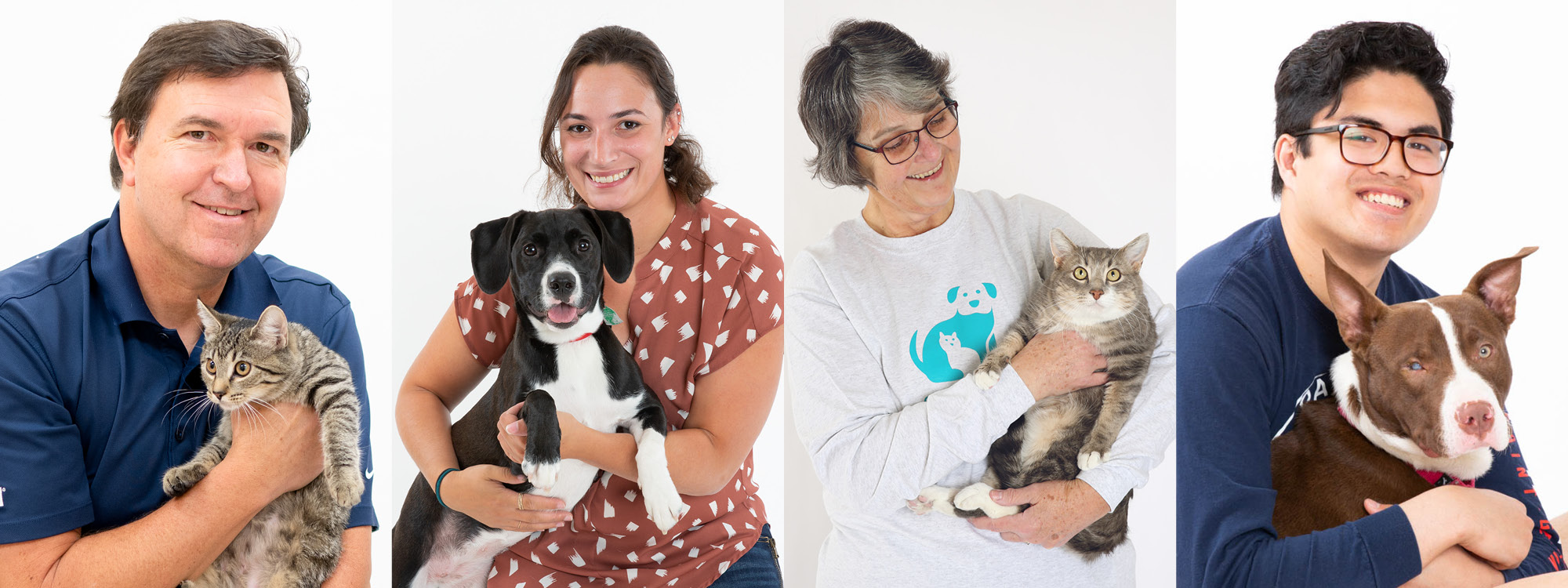 Various volunteers holding animals in their arms
